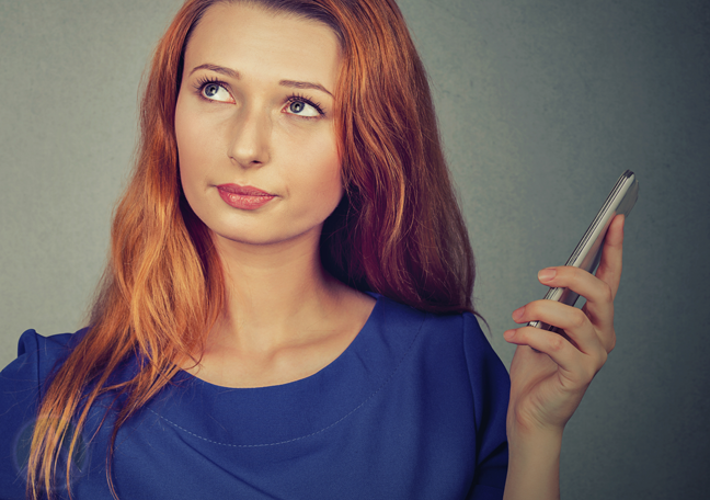 woman holding smartphone looking away