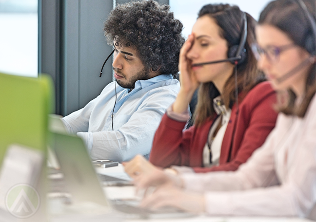 young tired bored call center reps at work