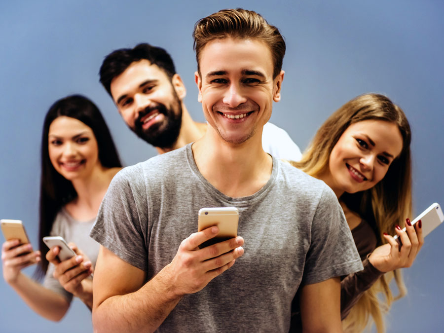 smiling group of friends holding phones