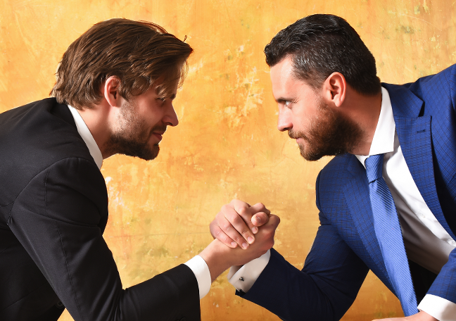 coworkers arm wrestling showing employee rivalry