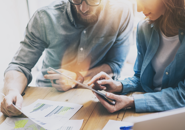 office executives in meeting discussing printed document