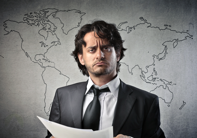 worried businessman holding paper with world map backdrop 