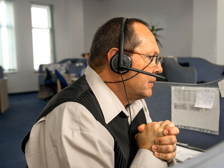 man in call center assisting consumers over customer support channel phone