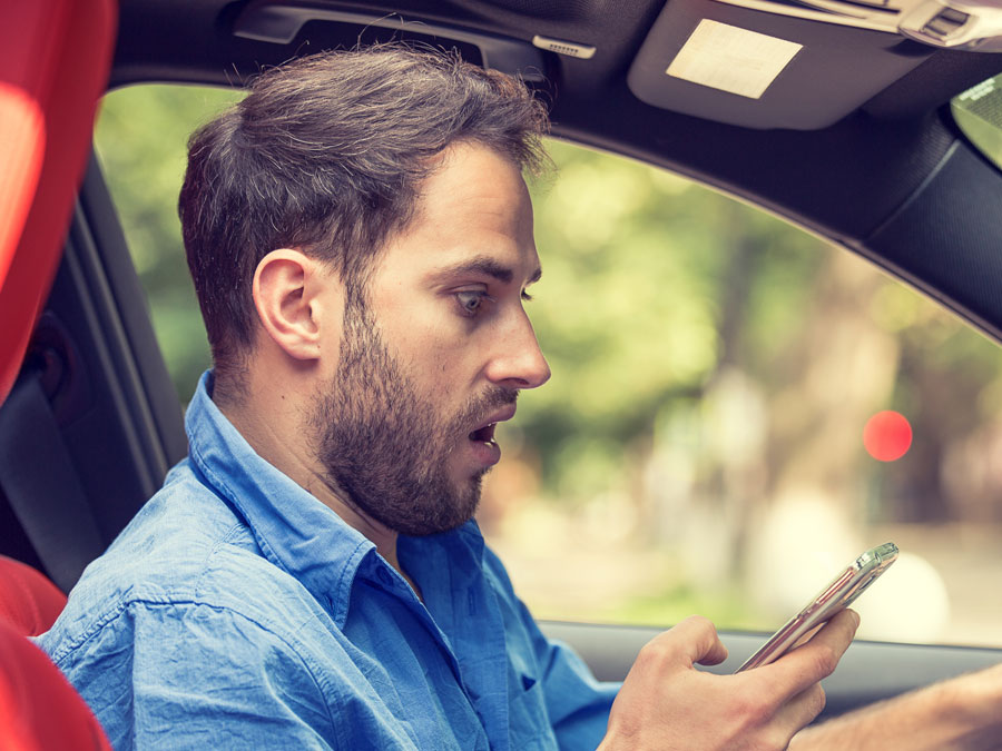 surprised man in car staring at phone