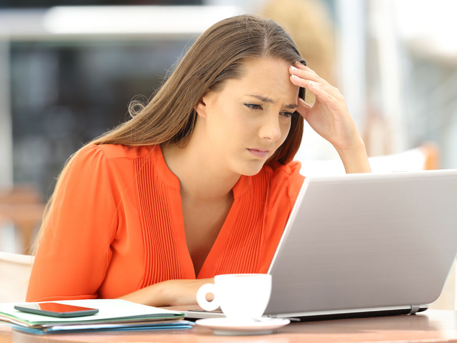 worried employee using laptop coffee