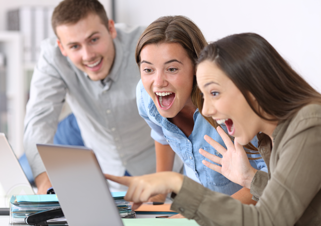 delighted excited business team in office looking pointing laptop