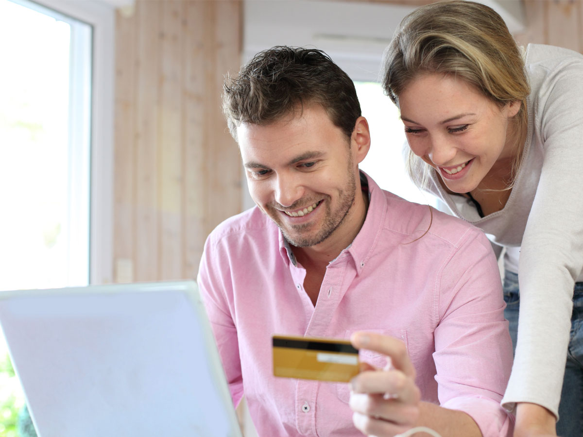 couple happily online shopping on ecommerce website using laptop