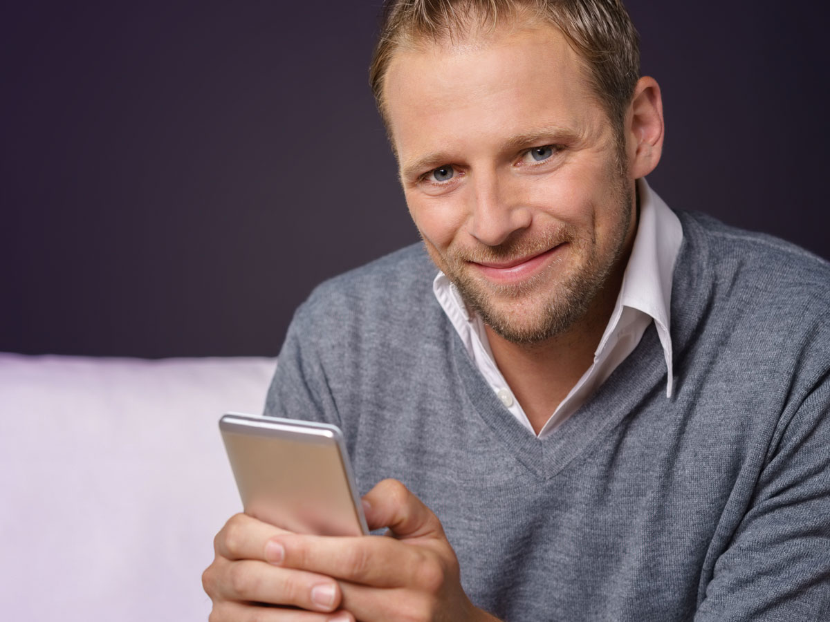 smiling man holding mobile phone 