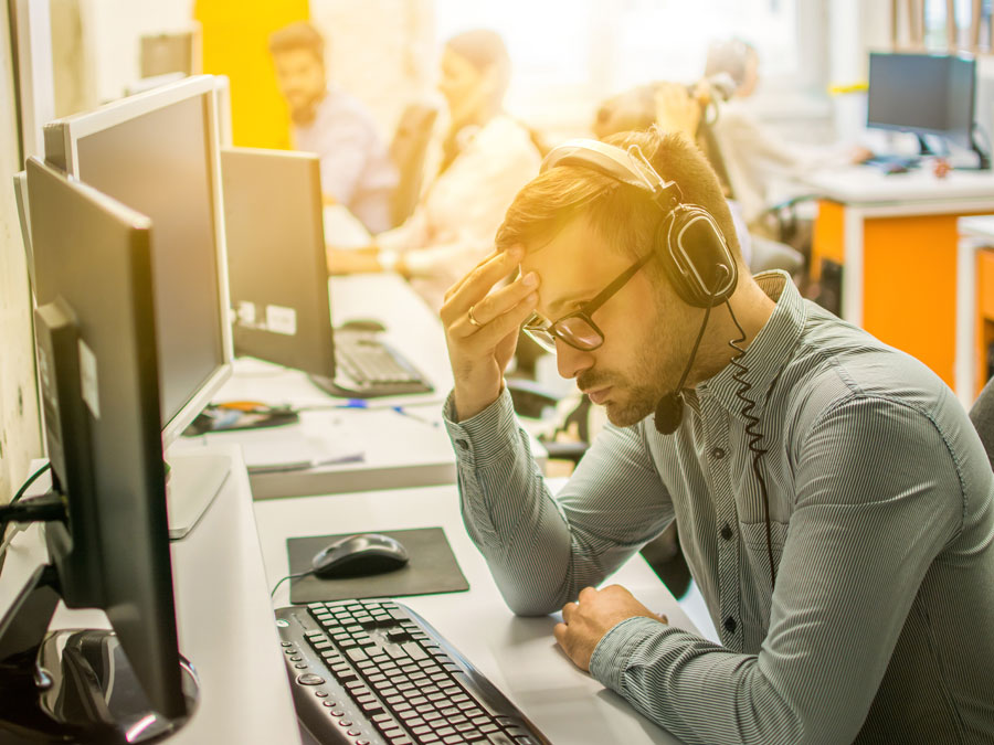 call center agent with a headache problematic in toxic workplace