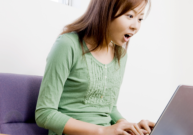 surprised young woman using laptop