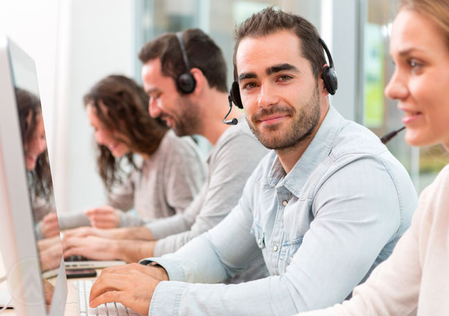 smiling call center agent surrounded by customer support coworkers