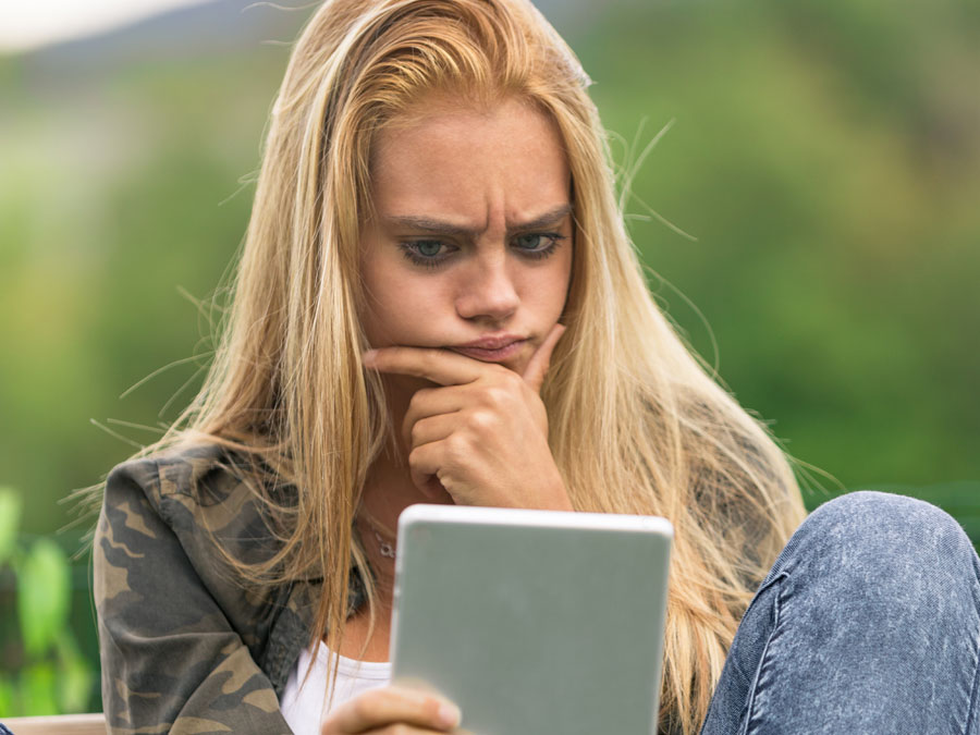content moderation services depiction woman staring at tablet reaction to doxing