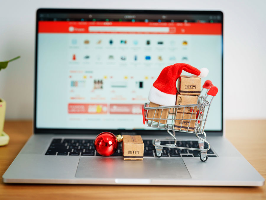 ecommerce brands depiction shopping cart santa hat gifts on laptop computer online shopping website