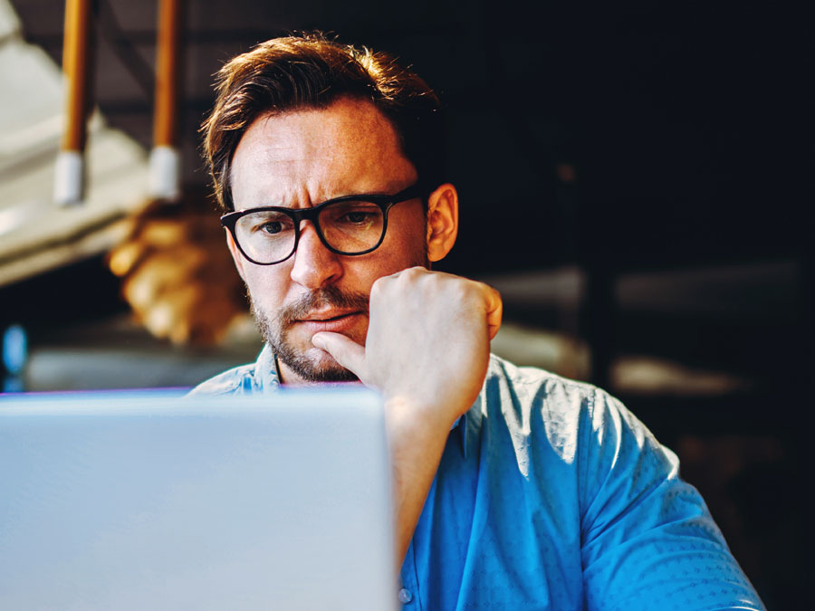 Stressed executive looking at laptop oabpo price sacrifices for amazing cx