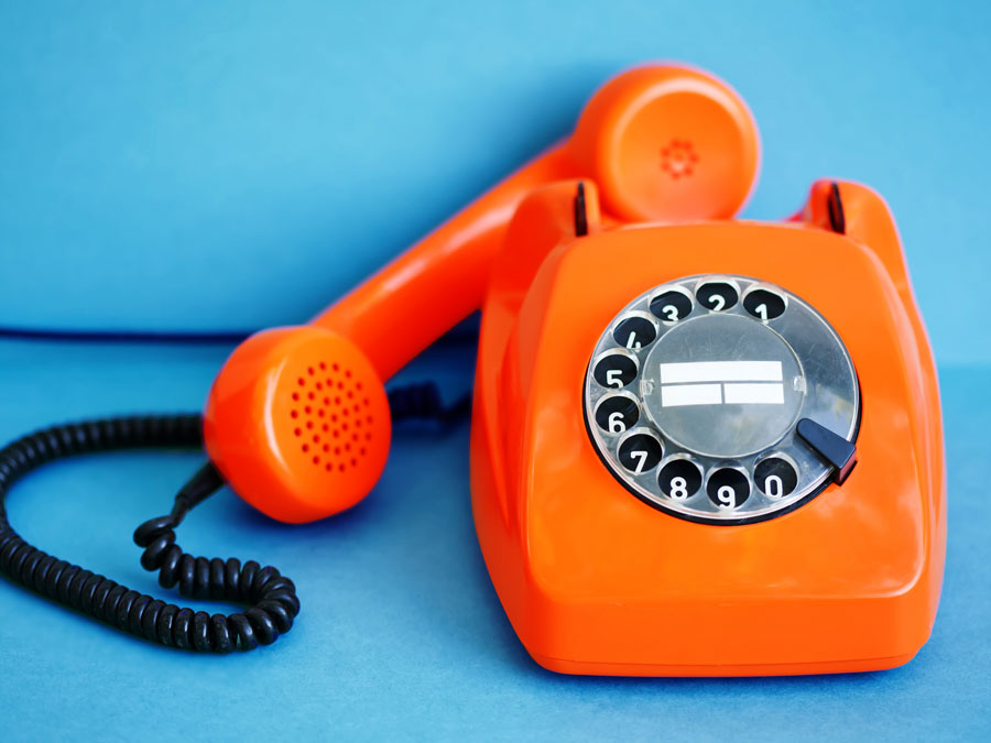 call center technologies depiction orange telephone on blue wall