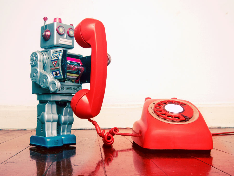 call center technologies depiction toy robot using landline telephone
