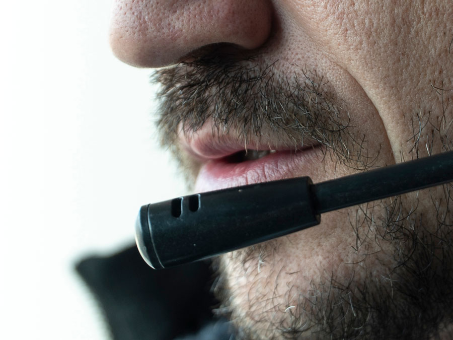 close up of CX rep mouth breaking bad news to customer over phone in contact center