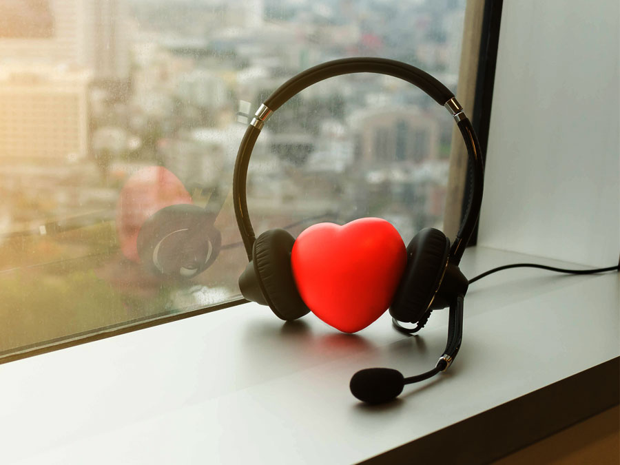 customer service depiction heart with call center headphones on office window