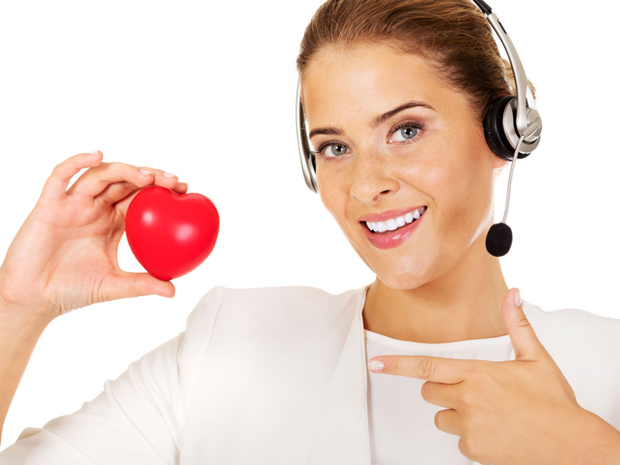 customer support rep holding red heart in call center