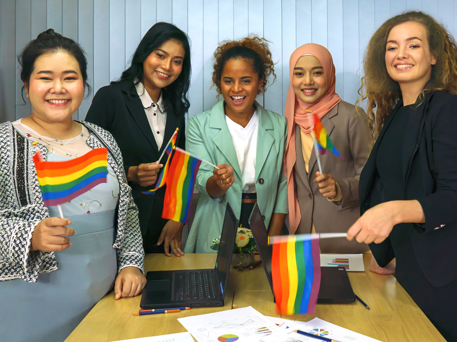 diverse women on multilingual call centers in the Philippines holding rainbow flags for pride month