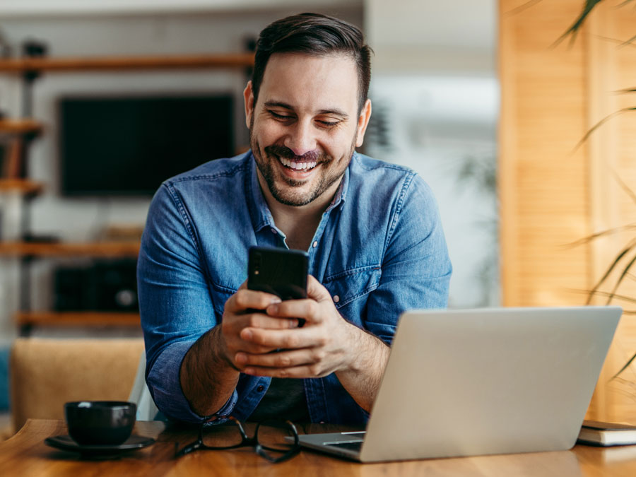 excellent customer engagement depiction man smiling using laptop smartphone