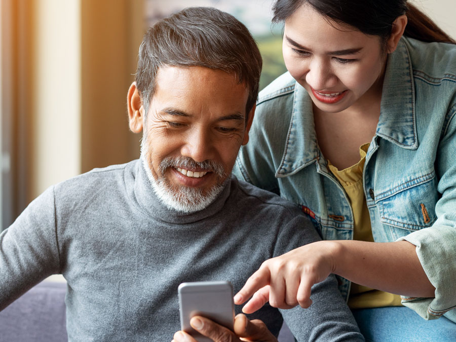 great customer experience depiction daughter showing ecommerce mobile website to father