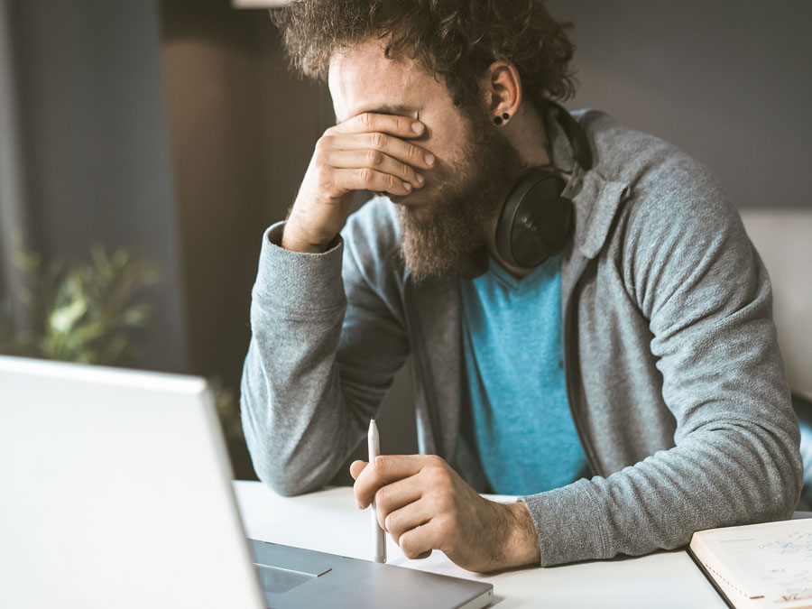 low customer satisfaction consumer facepalm in front of laptop