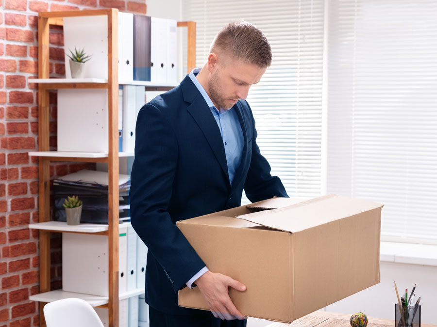 resigning call center agent looking down carrying box