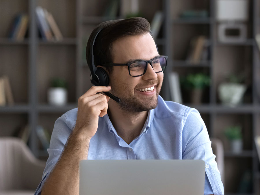 smiling customer satisfaction agent listening to customer on the phone in call center