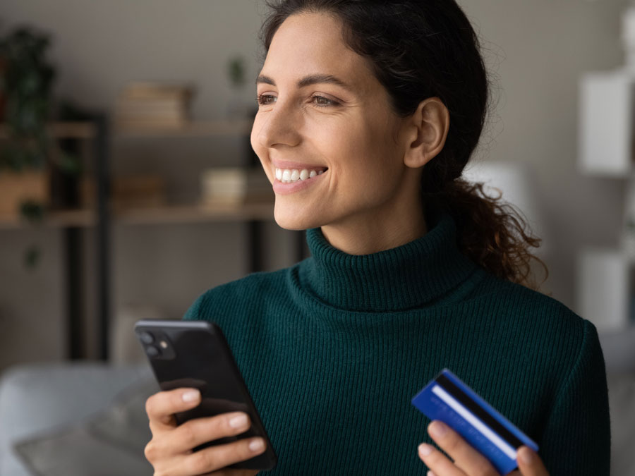 voice of the customer depiction smiling woman holding phone credit card