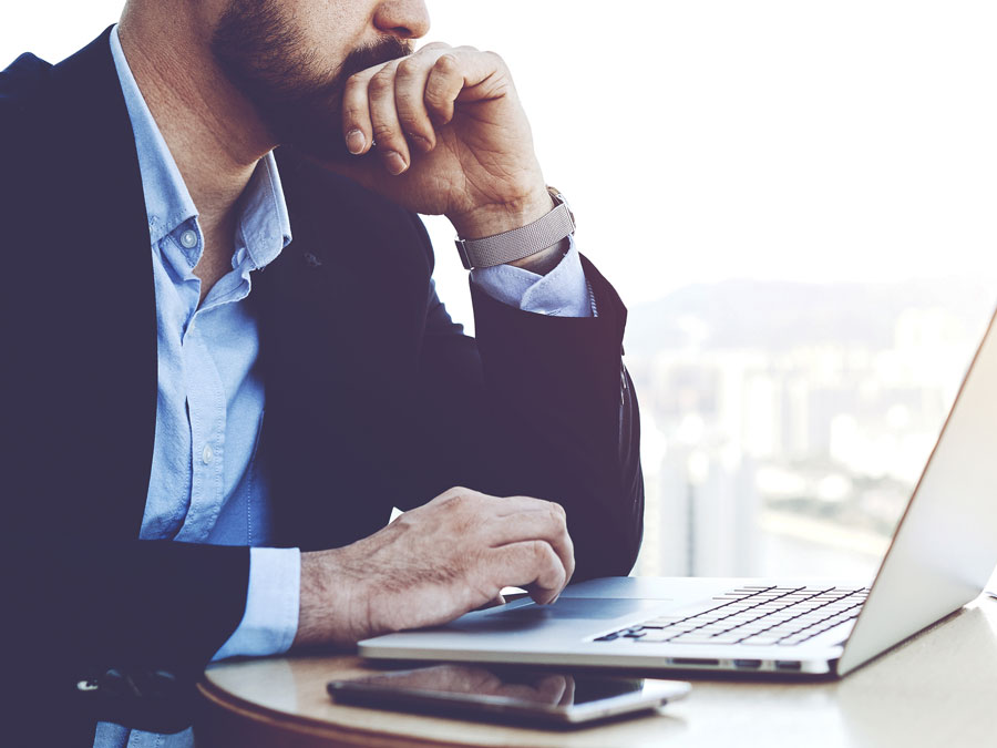 worried businessman outsourcing customer service looking at laptop