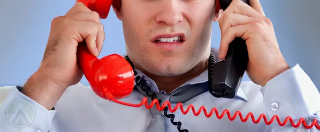 male-agent-holding-two-telephones