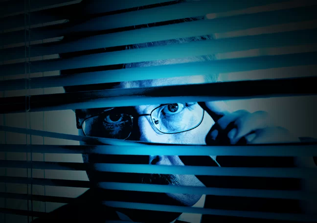businessman-peeking-through-window-blinds