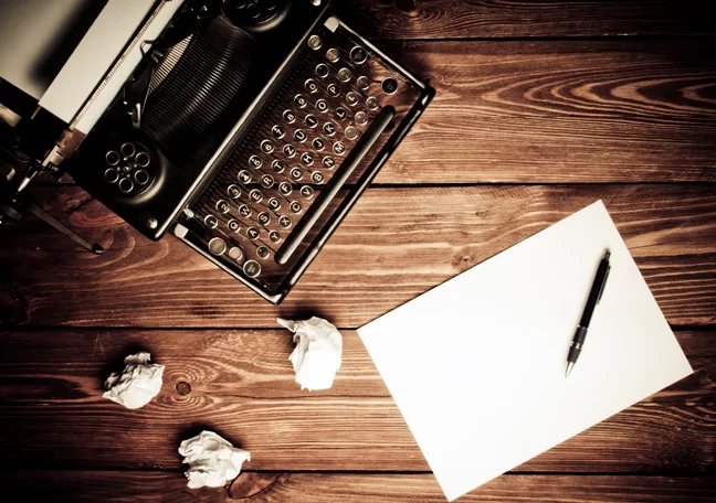 vintage-typewriter-with-pen-paper-crumpled