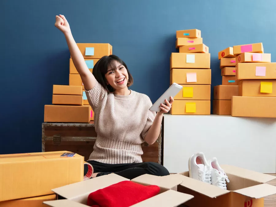 Excited woman ecommerce online shopping surrounded by boxes