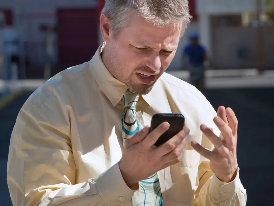 frustrated man looking at smartphone
