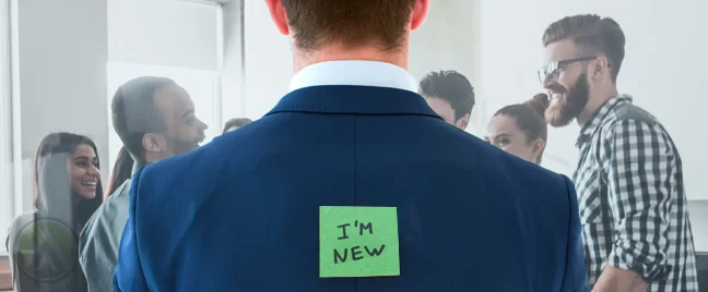 new employee in suit to his back with im new post it note