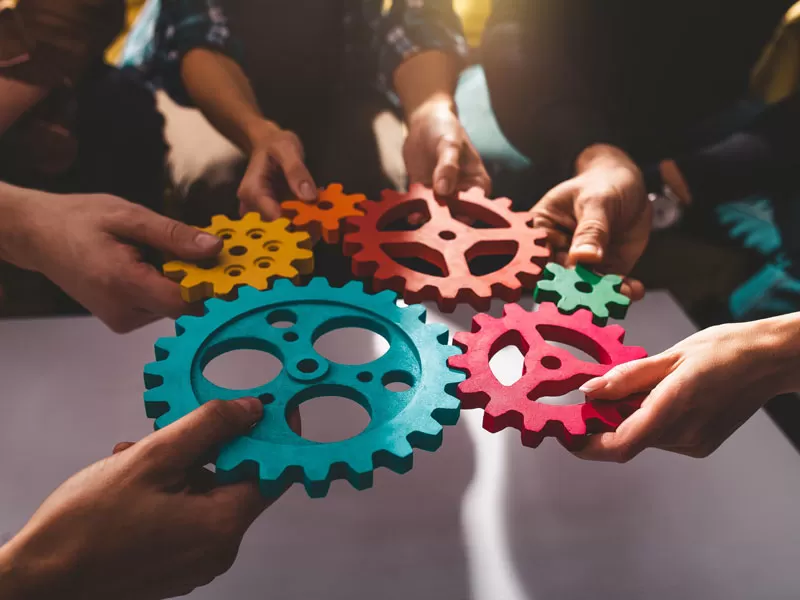 Outsourcing call center support system depiction brand executives holding wheels cogs
