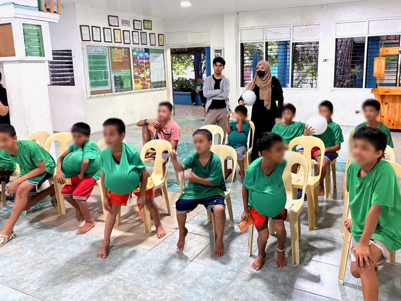 Community outreach programs by Open Access featuring children participating in a fun balloon game with volunteers during an engaging community outreach event.