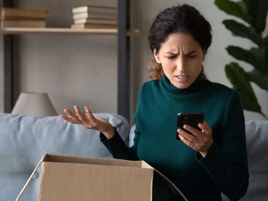 customer satisfaction concern depiction woman annoyed at defective product in box calling customer service hotline